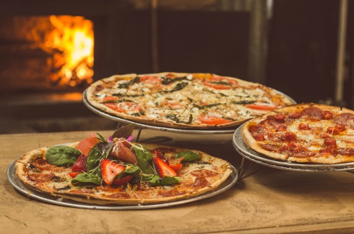 Tre pizzaer der har været en tur i en pizzaovn. Vidst du i øvrigt, at der findes pizzaovne til grillen?